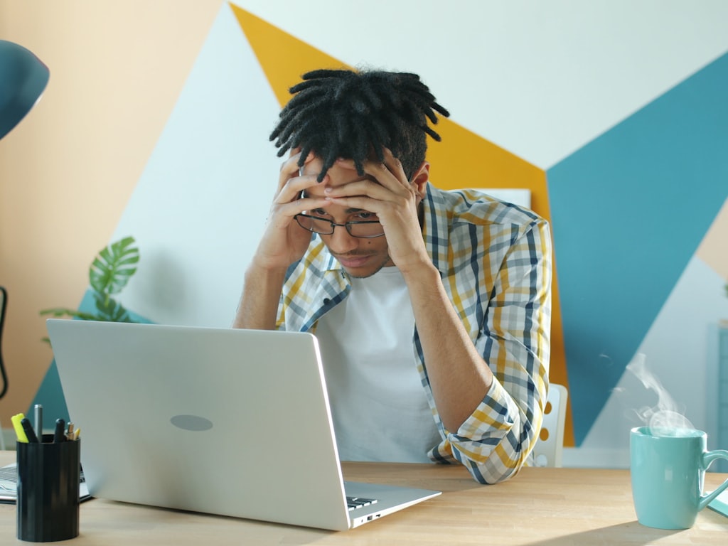 A frustrated person at a laptop
